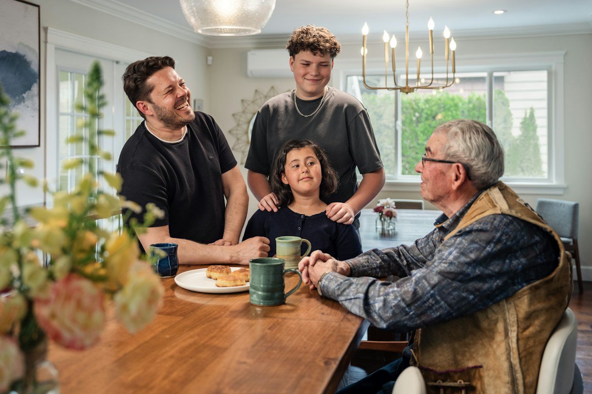 Familia reunida alrededor de una mesa, imagen ilustrativa