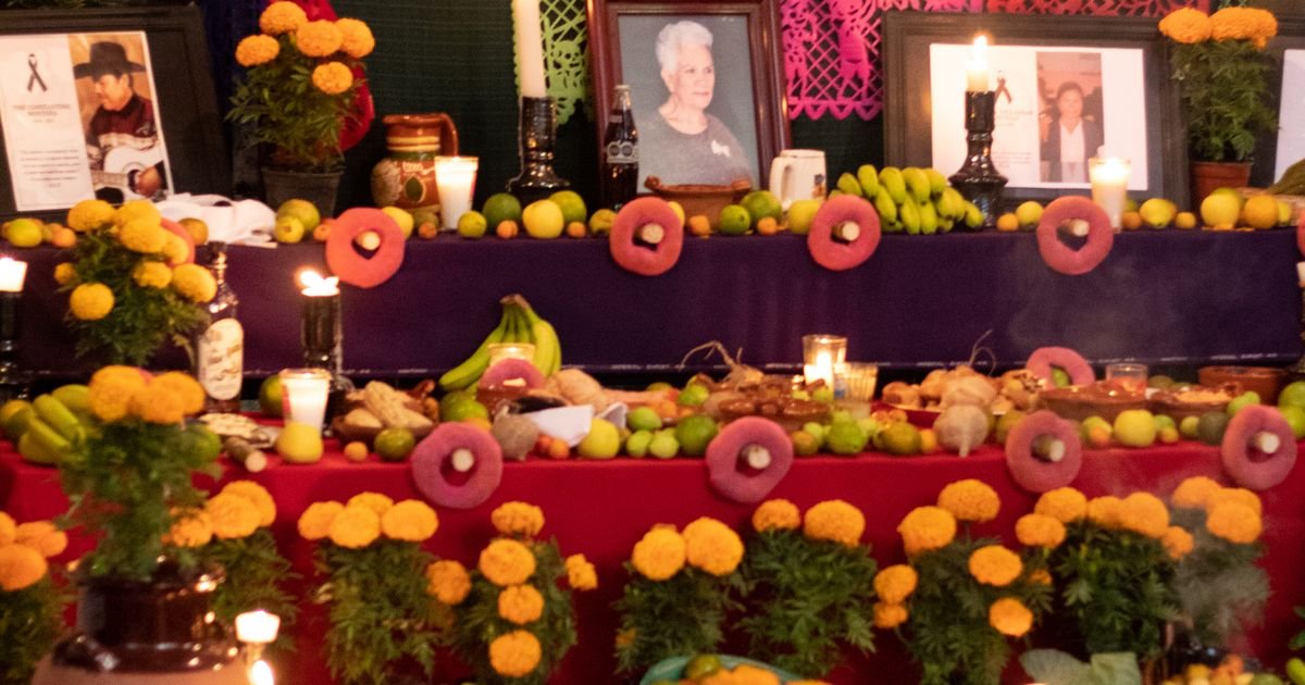 Altar de Día de Muertos con retratos, flores y alimentos