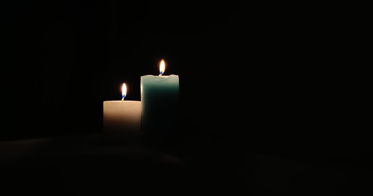 Dos velas encendidas sobre un fondo oscuro