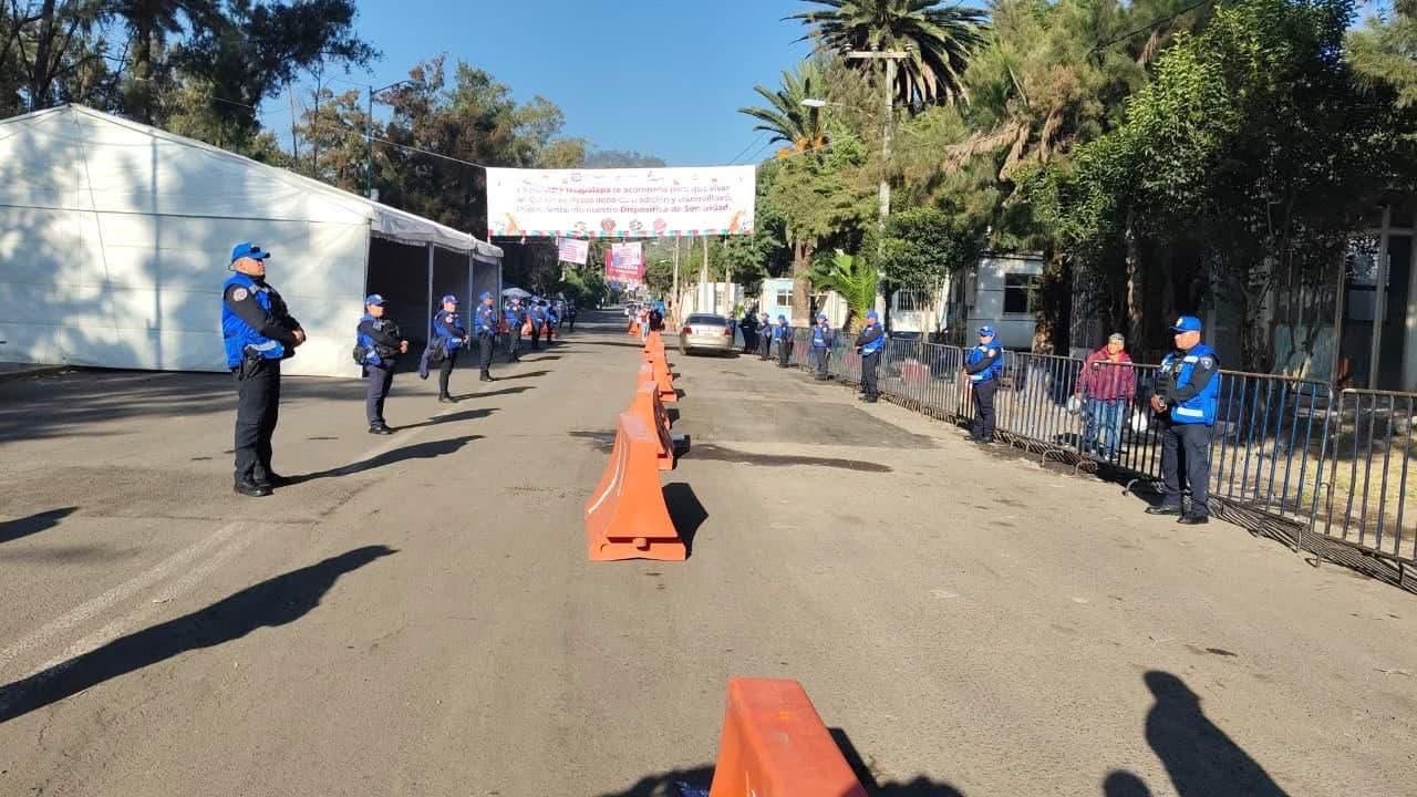 Personal de seguridad y barreras de orientación en un acceso a los panteones de Iztapalapa